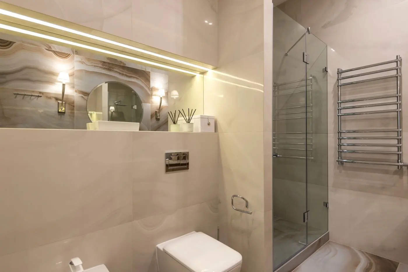 Badkamer met marmerachtige tegels, douche en LED-verlichting